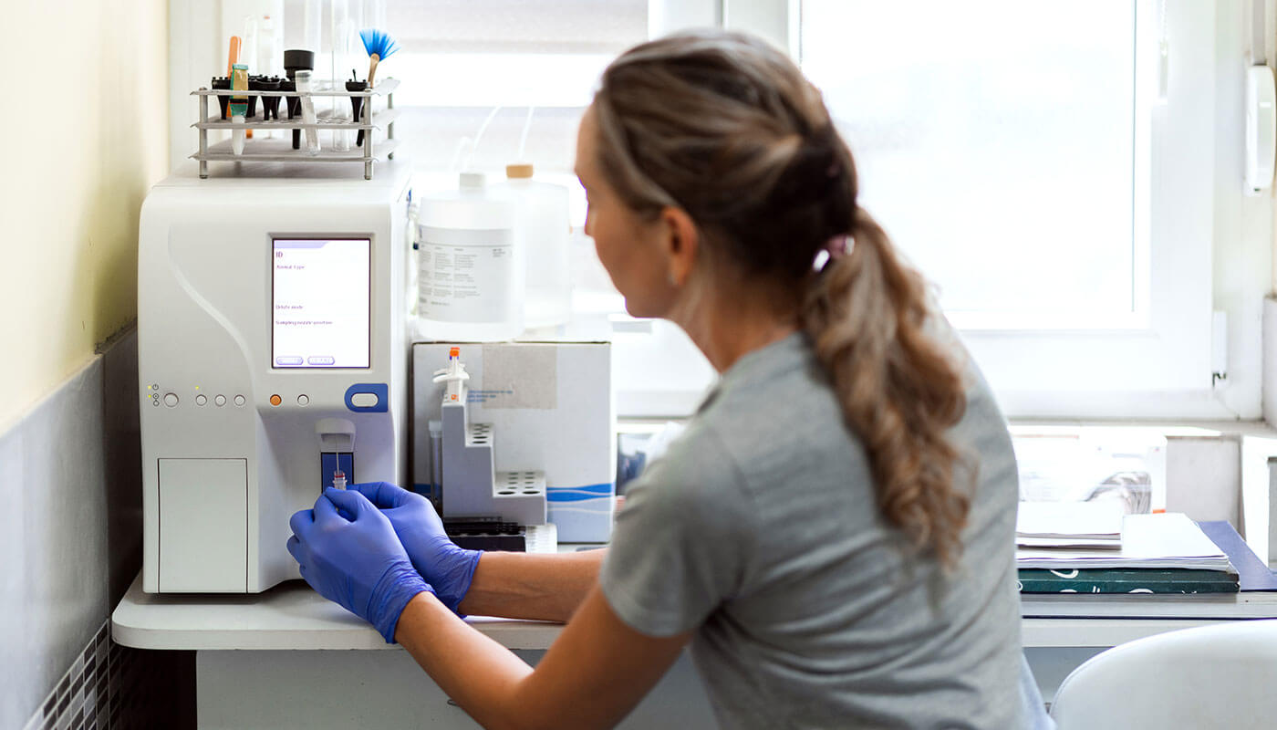 Veterinary technician operating a laboratory centrifuge for sample processing